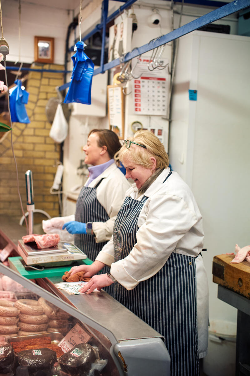 Two women working behind a meat counter in Cork's English Market.
